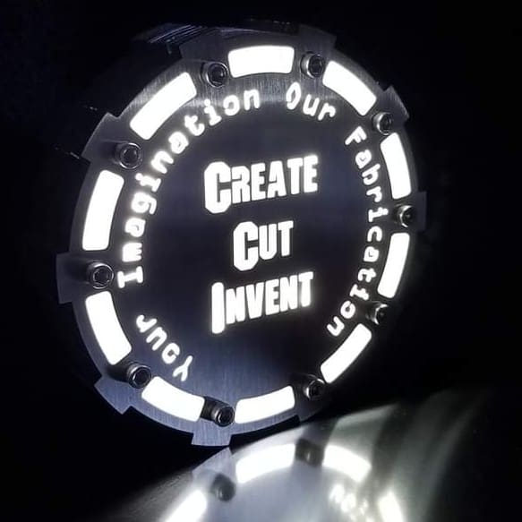 A circular light with the words " create cut invent ".